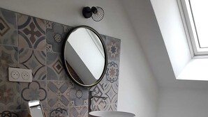 A compact bathroom with a washing machine, a sink with a wooden countertop, a toilet, and a skylight. - La Sirène, Entre le zoo de Beauval et les Châteaux de la Loire (Romorantin-Lanthenay)