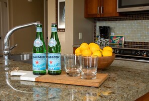 Eine Küchenarbeitsplatte mit Pellegrino-Flaschen, einer Zitronenschale und Gläsern.