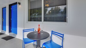 A room with a round table, two blue chairs, a bottle, and two wine glasses. - Your Ideal 30-Day Furnished Retreat in Hallandale! (Hallandale Beach)