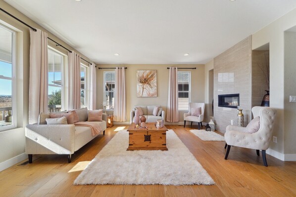 Relax in this stylish living room with a fireplace, sofa, and armchair.