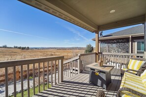 Relax on the outdoor deck with a table and chair, taking in the breathtaking views of the surrounding landscape.