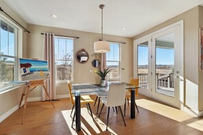 Enjoy meals in this dining area with a glass table and comfortable chairs, offering views of the surrounding landscape.
