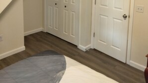 Een slaapkamer met een bed, een kast en een deur.