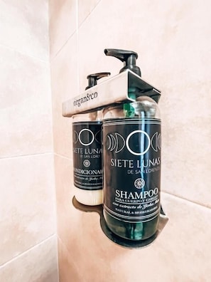 A bathroom with a hand dryer and two bottles of shampoo. - Siete Lunas Hotel Boutique (Villa San Lorenzo)