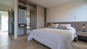 Un dormitorio con cama, mesita de noche, armario empotrado y televisión.