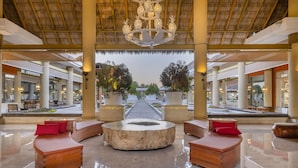 A spacious lobby with a central seating area, a thatched roof, and a view of the surrounding landscape. - Iberostar Selection Playa Mita - All Inclusive (Punta de Mita)