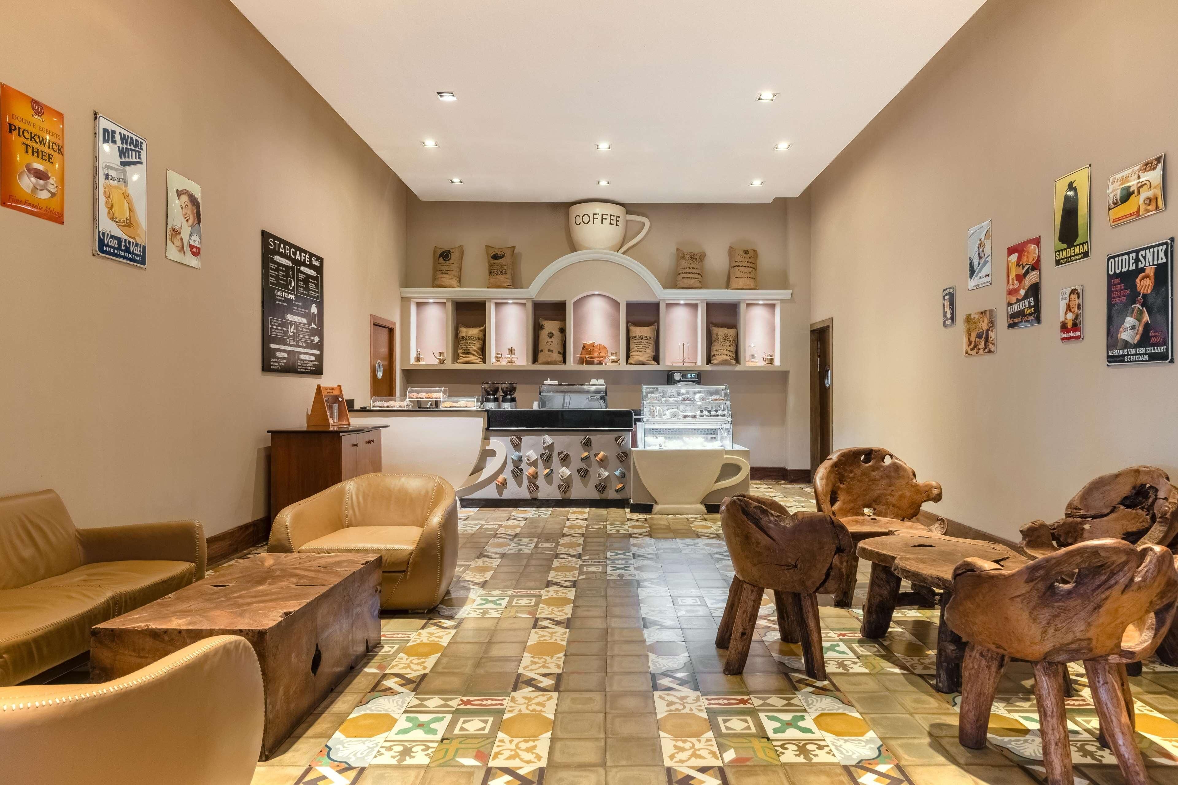 Ein gemütliches Café mit Ledersofas, Holzsesseln und einer Kaffeebar.