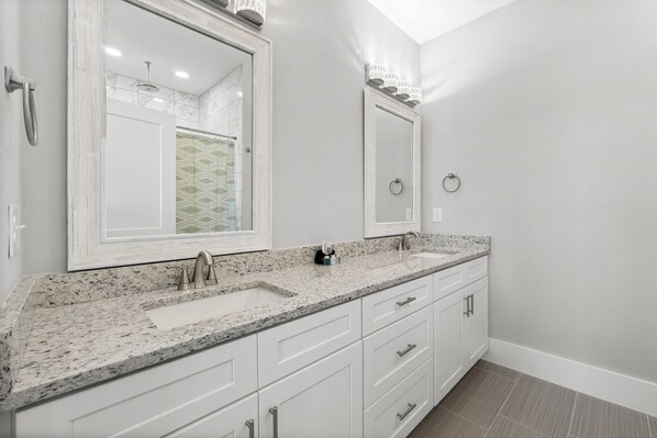 A bathroom with two sinks, white cabinets, and a large mirror. - 22704 Front Beach Road Ocean Breeze (Panama City Beach)