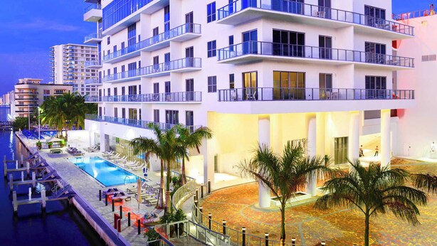 A multi-story hotel with a pool, palm trees, and balconies. - Stunning 25th-Floor Views in Hollywood (Hollywood)