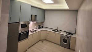 Cocina compacta con horno integrado, microondas y lavadora.