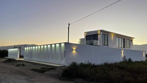 Un edificio moderno con techo plano, amplias ventanas y fachada bien iluminada.