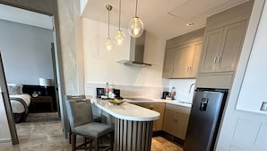 A modern kitchen with a central island, stainless steel appliances, and pendant lighting.