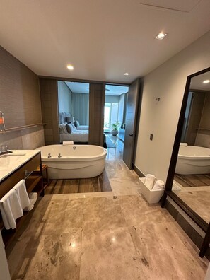 Une salle de bain moderne avec une grande baignoire, un meuble-lavabo avec un miroir et un espace douche.