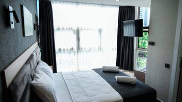 Habitación triple familiar, vista a la ciudad | Espacio para trabajar con laptop y insonorización