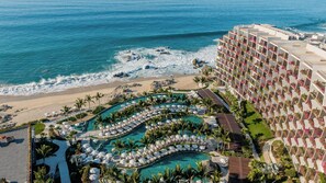 Relax by the infinity pool overlooking the ocean, or unwind on the adjacent beach with sun loungers and a sandy shore.