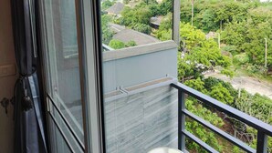 Ein Balkon mit Blick auf die Küste, ein kleiner Hocker und ein dekoratives Anhänger.