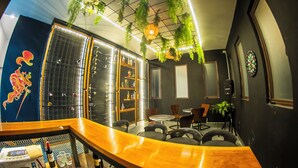 A modern bar area with a curved wooden counter, seating, and hanging plants. - Hotel Boutique Monte Penasco (Jilotepec)