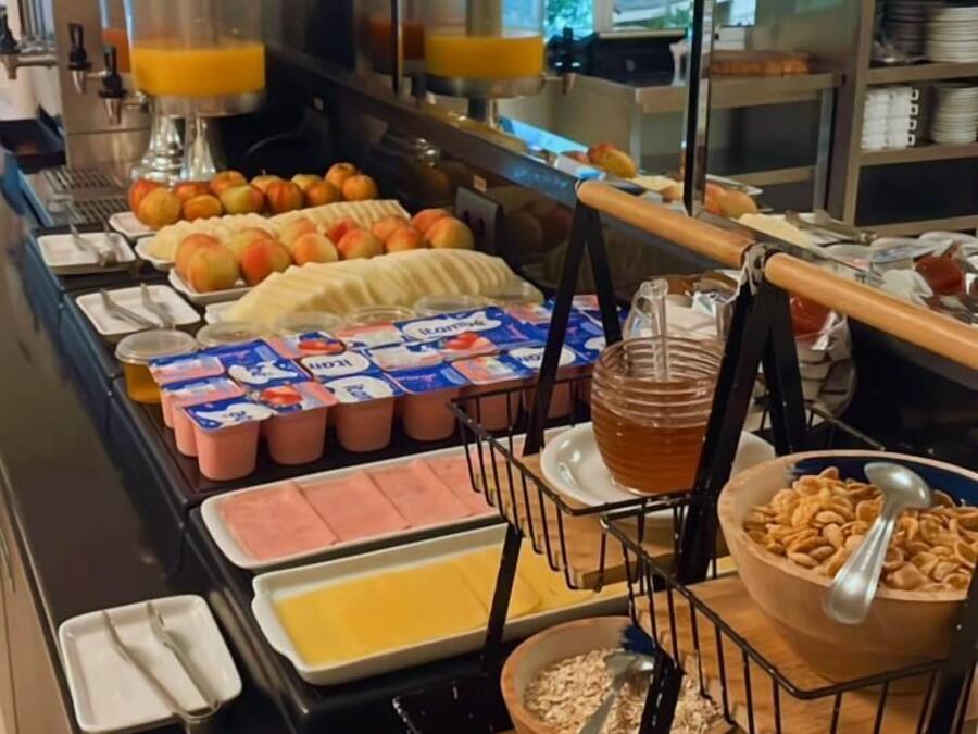 A buffet with various food items including fruits, yogurt, and cereal.