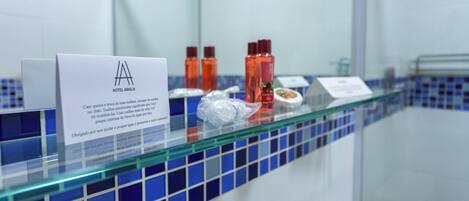 A hotel reception area with a glass counter, a sign with the hotel logo, and toiletries.