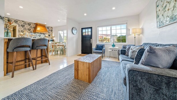 Un salon moderne comprenant un canapé, une table basse et un coin repas avec des chaises et une table.