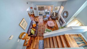 A spacious living area with a wooden staircase, a leather sofa, and a dining table. - 8-Guest Marina Beach Home Near Monterey Bay (Marina)