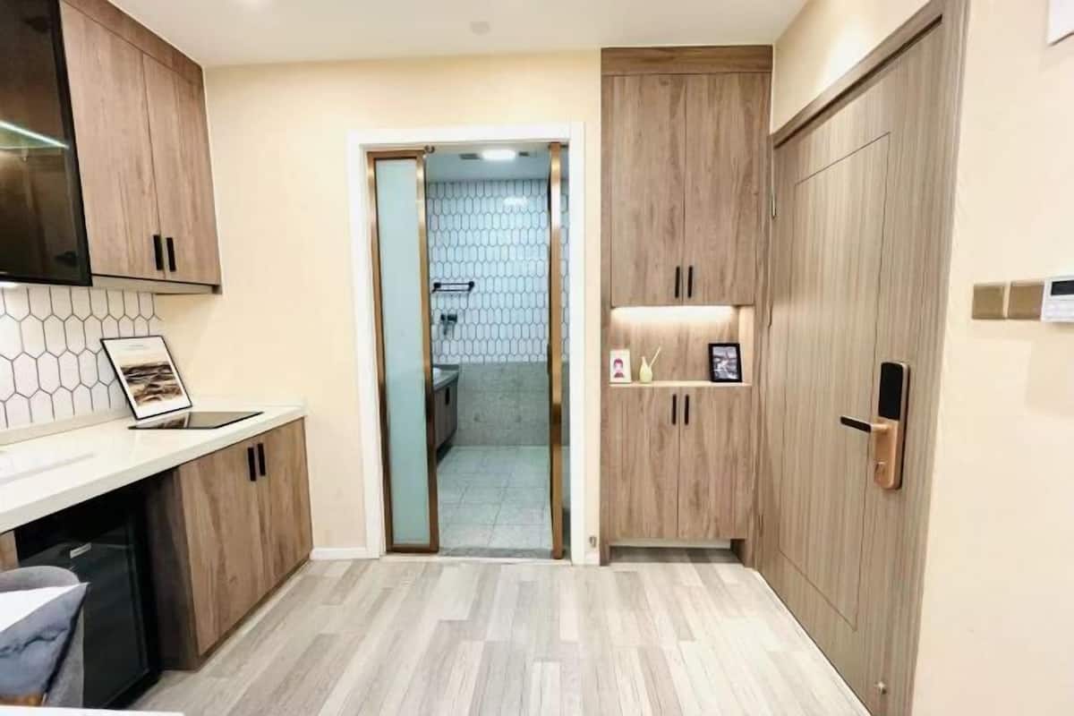 A modern kitchen with wooden cabinets, a tiled backsplash, and a built-in dishwasher.