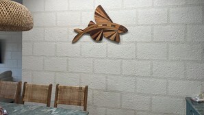 A dining area with a textured wall, a wooden airplane decoration, wicker chairs, and a table with a marble-like surface. - Villa By The Bay
Luxury 3 bedroom all ensuite, private pool, pickleball court (Bridgetown)