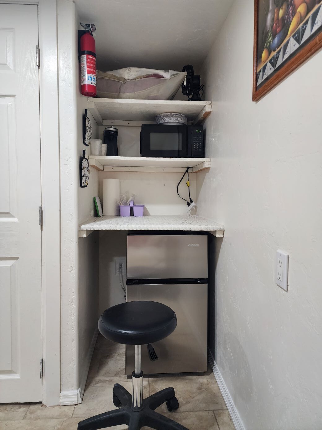 A compact kitchenette with a microwave, a small refrigerator, and a sink.