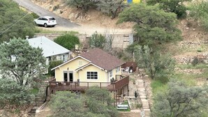 Une maison à deux étages dotée d’une terrasse, d’un porche à l’avant et d’un escalier menant à l’étage supérieur.