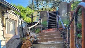 Un escalier en béton menant à un bâtiment doté d’une fenêtre et d’une porte.