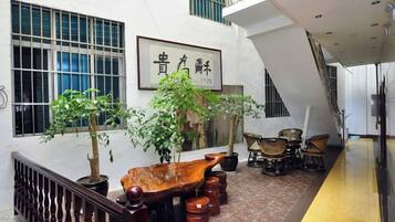 Un interior moderno con un banco de madera, plantas en macetas y muebles tradicionales.