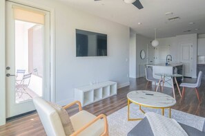 A modern living room with a flat-screen TV, a round coffee table, and a seating area with a sofa and chairs. - Heart of Tempe 1BD with Pool, Gym, Parking (Tempe)