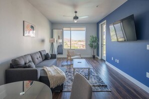A modern living room with a sectional sofa, a coffee table, and a TV mounted on the wall. - Tempe Convenience 1BD with Pool Gym Parking. (Tempe)