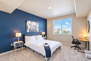 A hotel room with a bed, bedside tables, a desk, and a chair. - Heart of Tempe  Balcony, Pool, Gym, WD, Parking (Tempe)