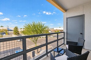 A balcony with a view of a parking lot and buildings, a door, and outdoor furniture. - Heart of Tempe  Balcony, Pool, Gym, WD, Parking (Tempe)