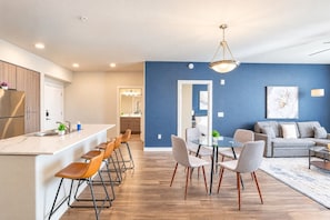 A modern apartment with a kitchen, dining area, and living room.