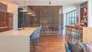 Une cuisine moderne dotée d’un îlot central, de meubles en bois et de luminaires suspendus.