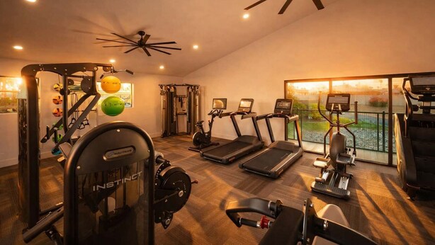 A gym with treadmills, a weight machine, and a ceiling fan. - Walk to Old Town Gym, Pool, WD, Pkg  Balcony (Scottsdale)