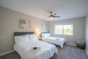 A hotel room with two beds, a ceiling fan, artwork on the walls, and a window providing a view. - Walk to Old Town Gym, Pool, WD, Pkg  Balcony (Scottsdale)