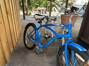 A blue bicycle parked on a concrete surface near a wooden fence. - The Great Gatsby - Luxury Historic Riverside (Jacksonville)
