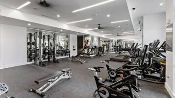 A gym with various exercise equipment, including treadmills, stationary bikes, and weight machines.