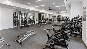 Ein modernes Fitnessstudio mit verschiedenen Trainingsgeräten, darunter Laufbänder, Ergometer und Kraftgeräte.