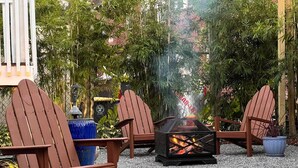 An outdoor seating area with Adirondack chairs and a fire pit. - Bright Airy Luxurious Abode in Walkable Riverside (Jacksonville)