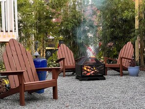 An outdoor seating area with Adirondack chairs and a fire pit. - Bright Airy Luxurious Abode in Walkable Riverside (Jacksonville)