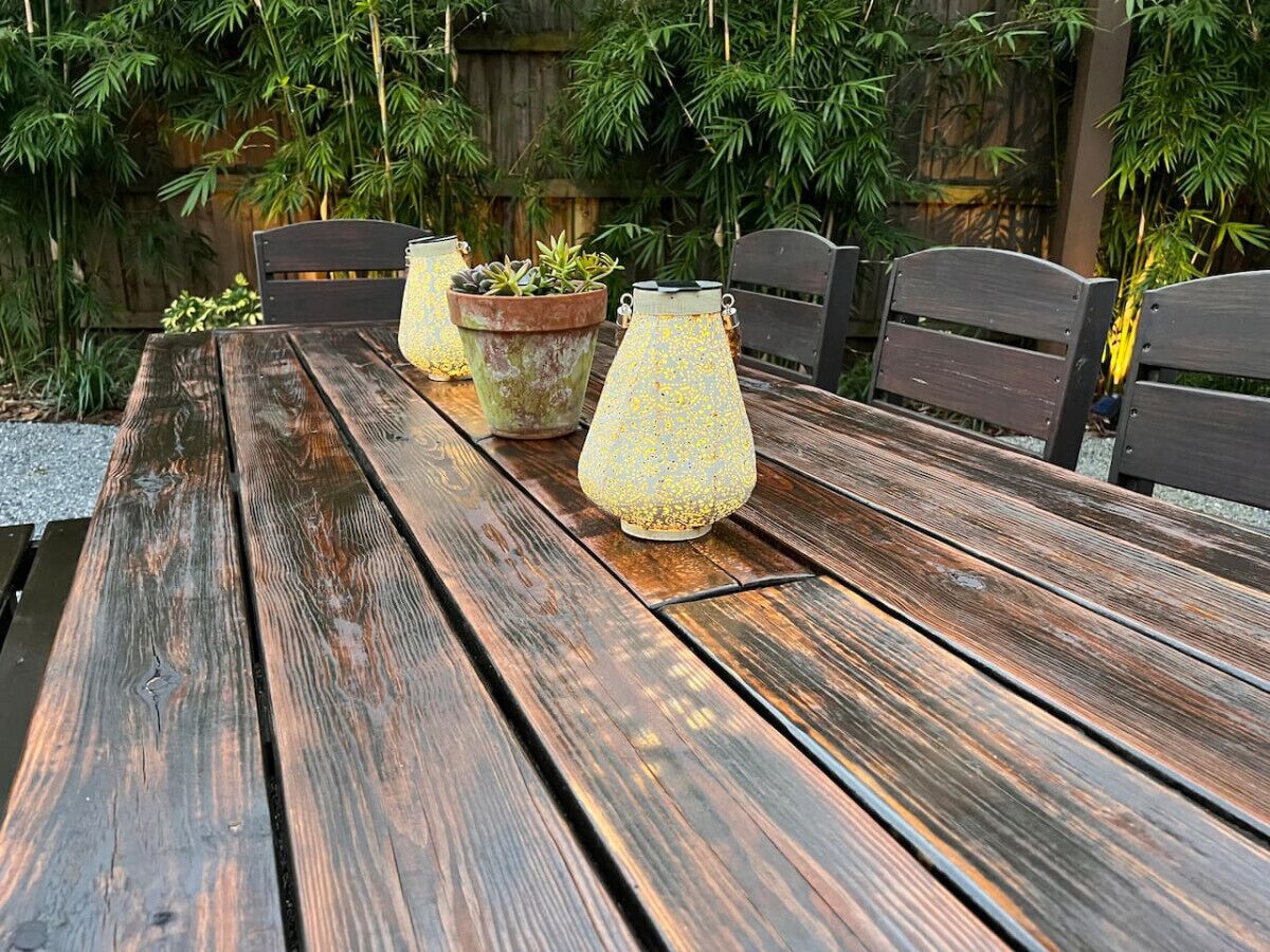 Una mesa de madera con dos plantas en macetas y una lámpara decorativa.