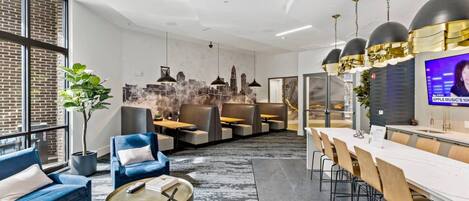A modern interior with a dining area, seating, and a television screen.