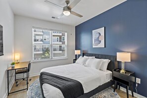 A bedroom with a bed, bedside tables, a desk, and a chair. - Near DT  CPCC Lynx with  Pool Gym WD Parking (Charlotte)