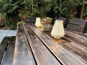 Una panchina in legno con tre piante in vaso e due lanterne.