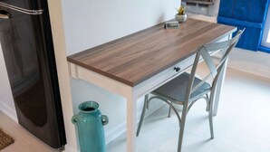 A kitchen with a wooden countertop, a blue vase, and a chair.