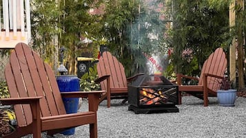 A fire pit with seating, surrounded by gravel and plants.